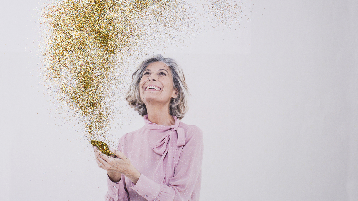 Mature woman looking at gold dust from phone