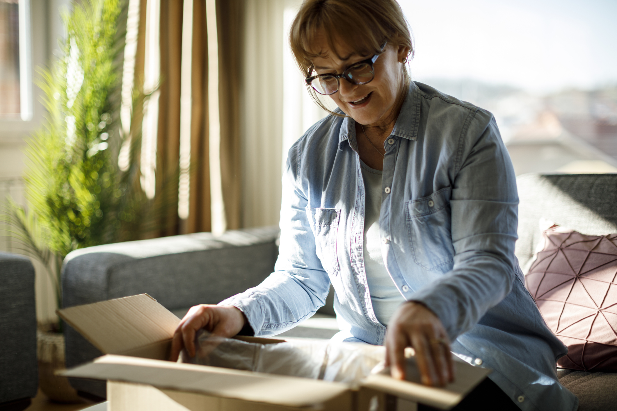 Excited senior woman unpacking online order