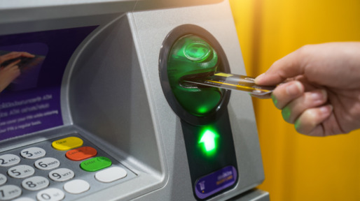 Woman hand is inserting card to atm machine to withdraw or transfer money