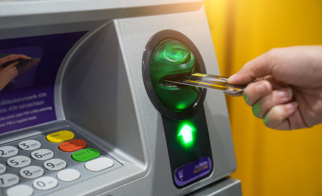 Woman hand is inserting card to atm machine to withdraw or transfer money