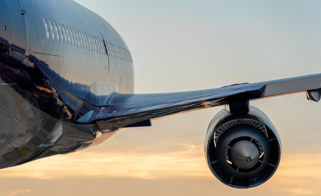 Passenger airplane taking off at sunset