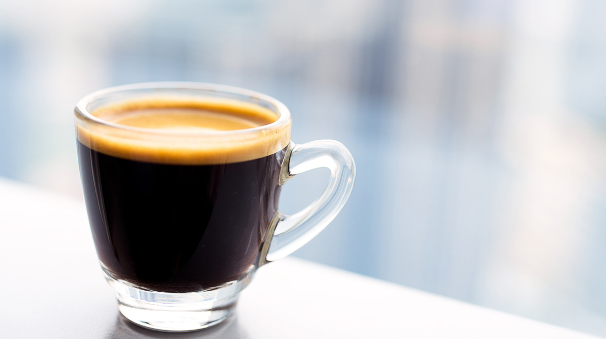 Tiny glass cup of espresso coffee