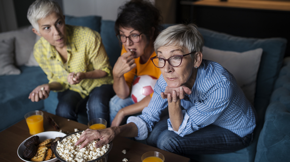 Senior women watching football on TV