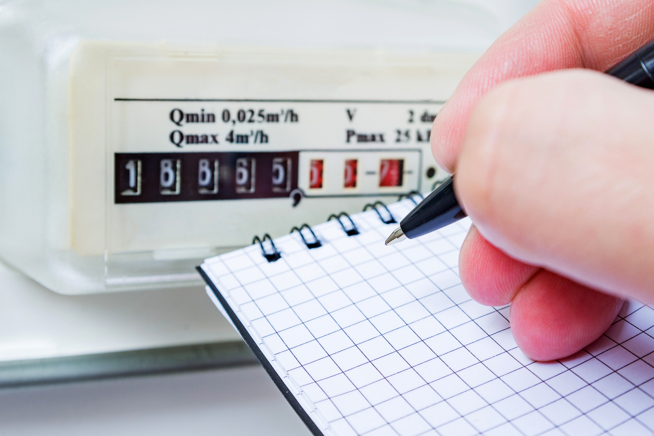 Man with pen and notepad writes the gas meter readings. Payment of utility services.