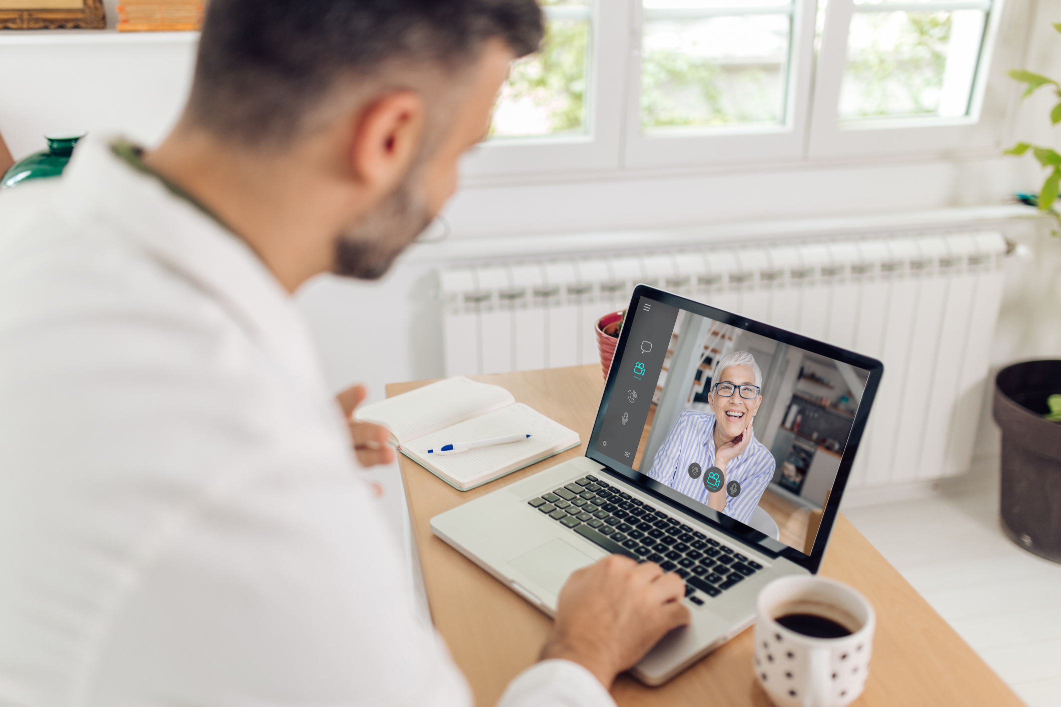Mid adult doctor is making an online checkup of his senior patient