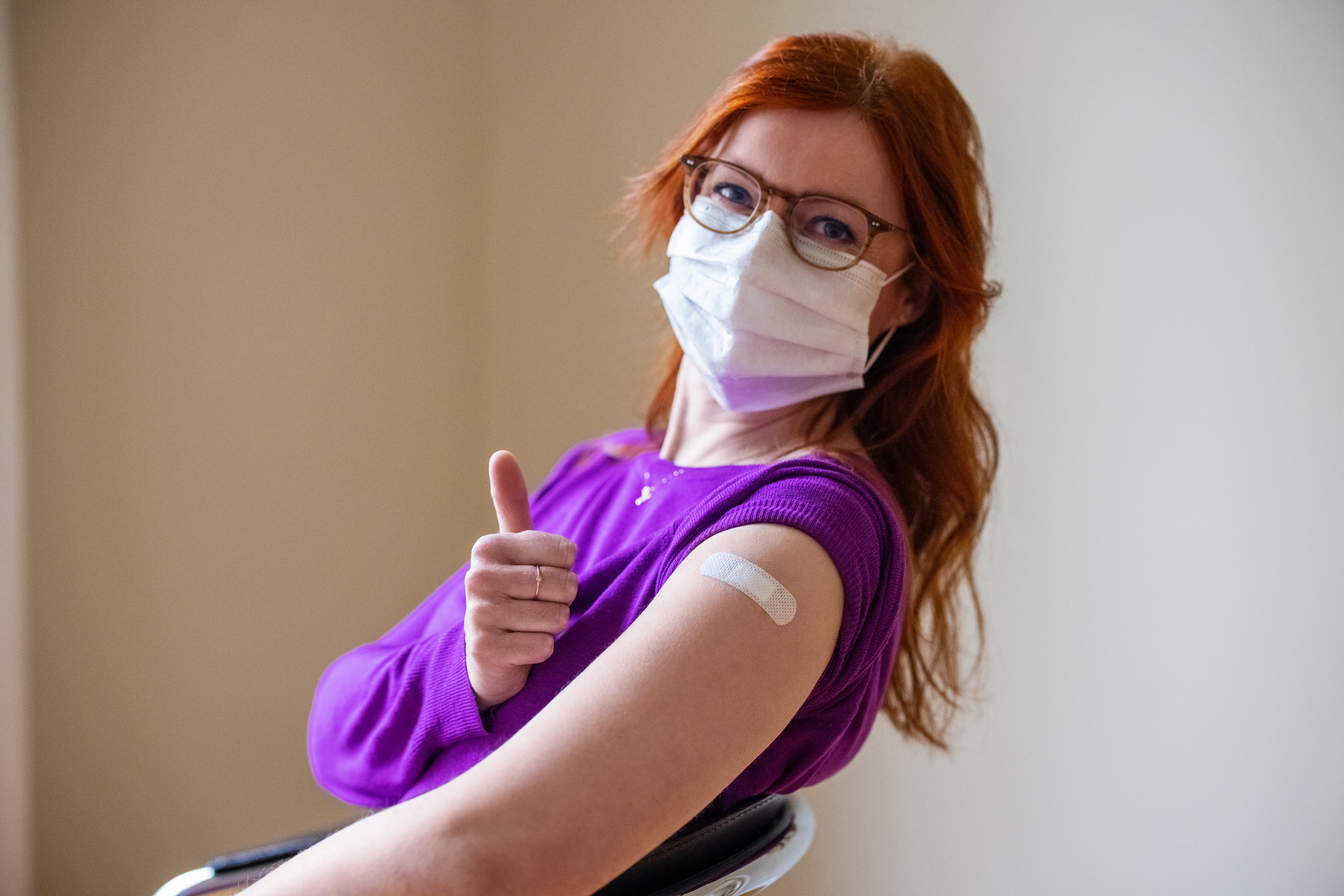 Woman showing thumbs up after getting covid-19 vaccine