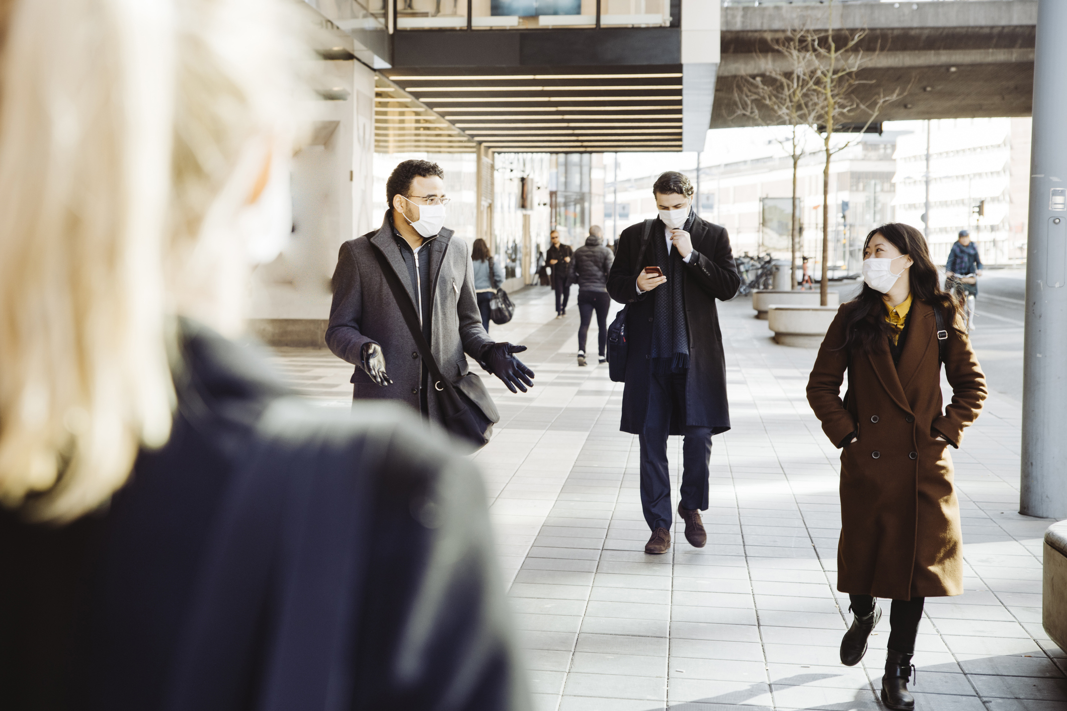 Business people wearing face mask walking in street