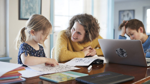 Mother homeschooling daughter and son at table