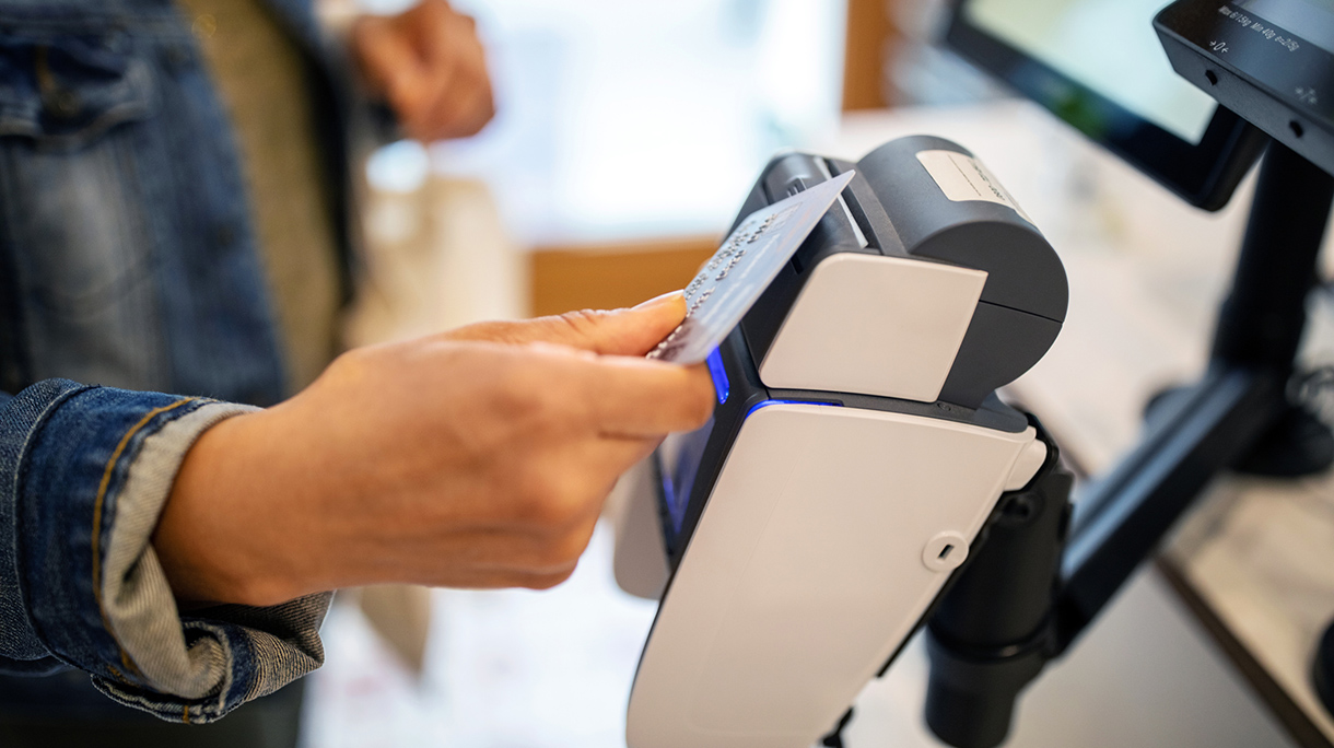 Woman using credit card for contactless payment at checkout