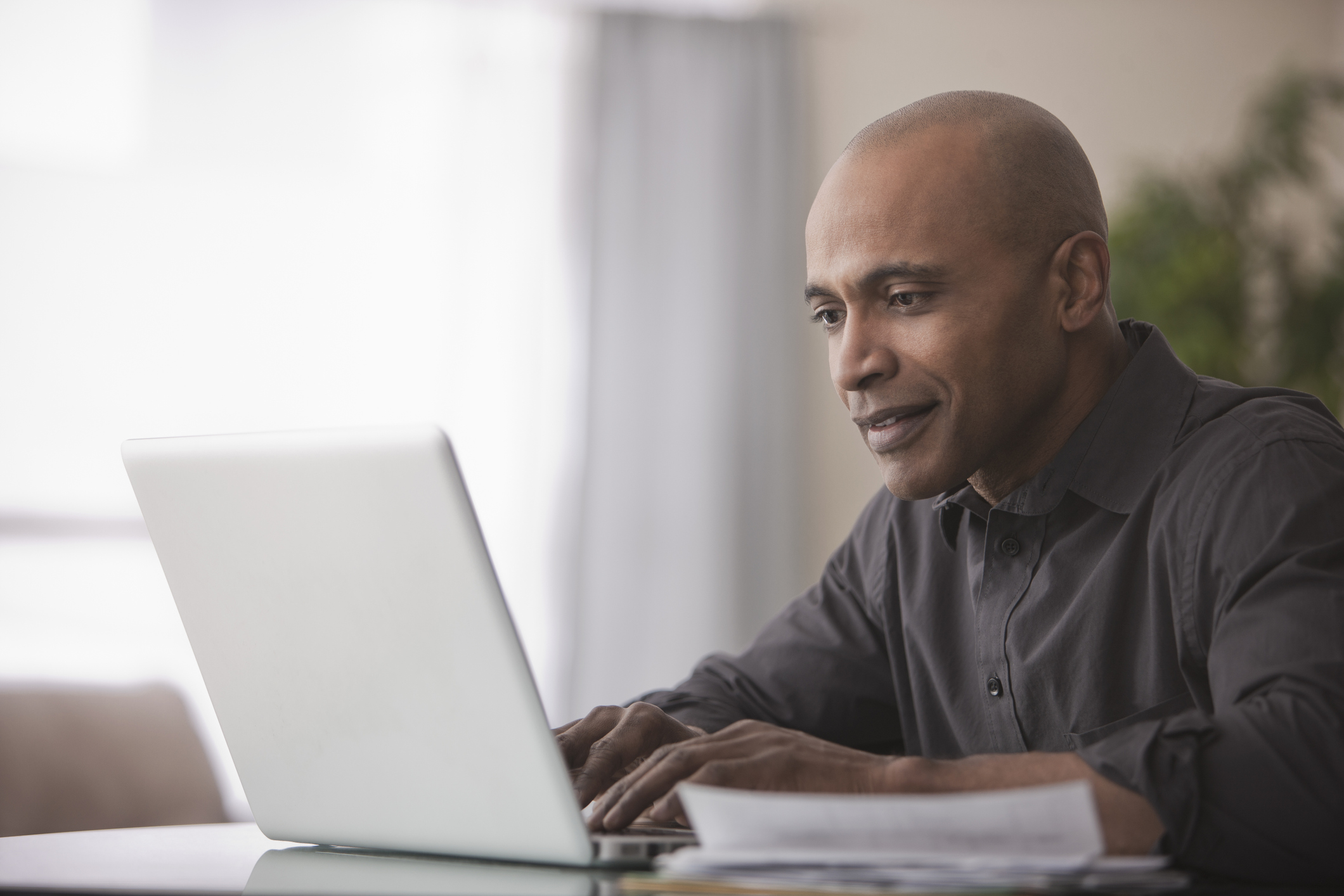 Black man typing on laptop