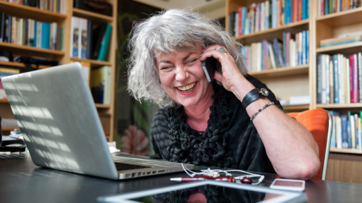 Woman laughing on the phone at home office