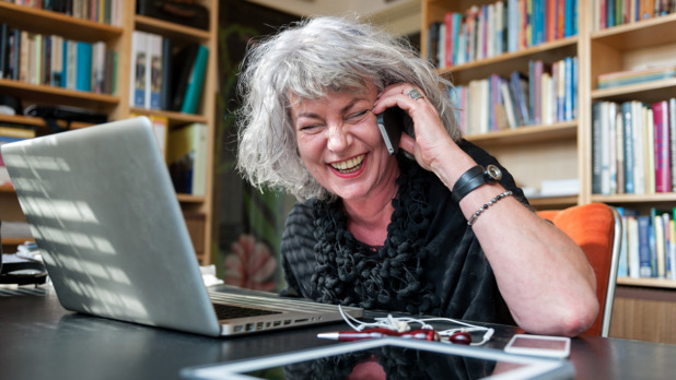 Woman laughing on the phone at home office