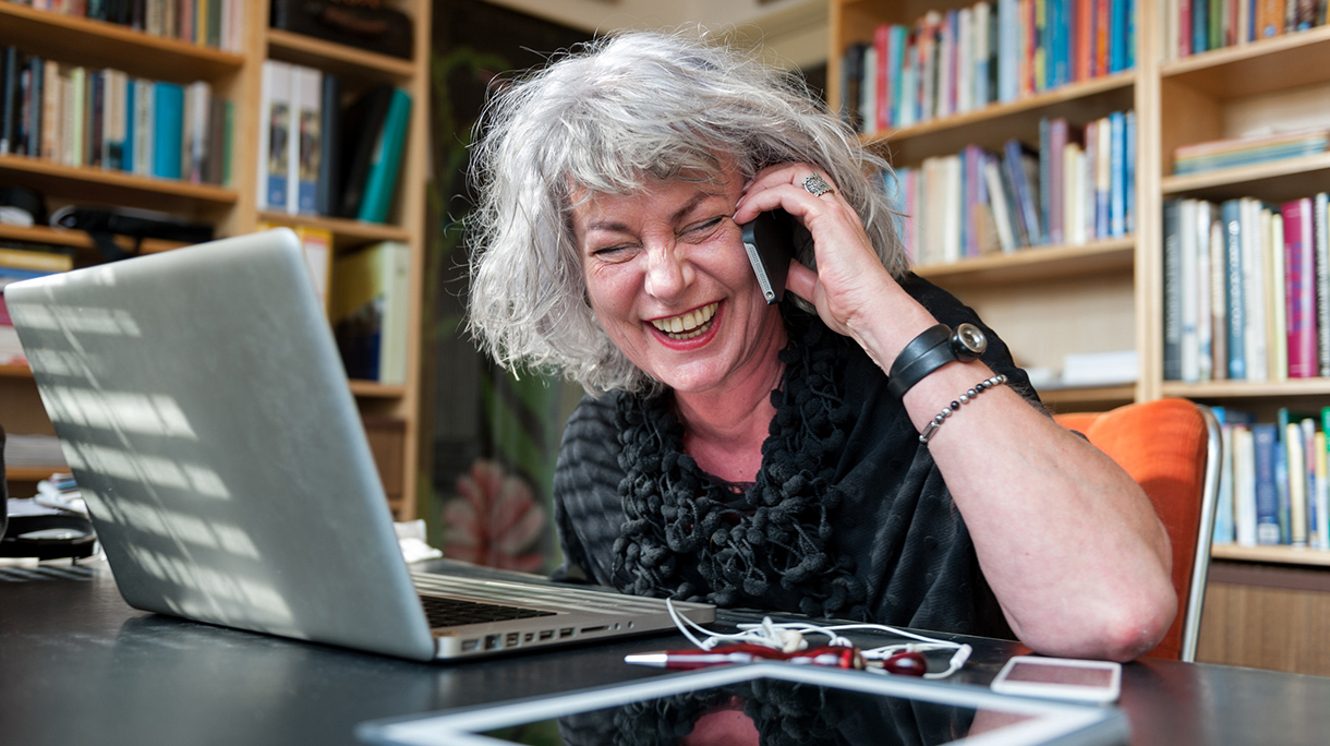 Woman laughing on the phone at home office