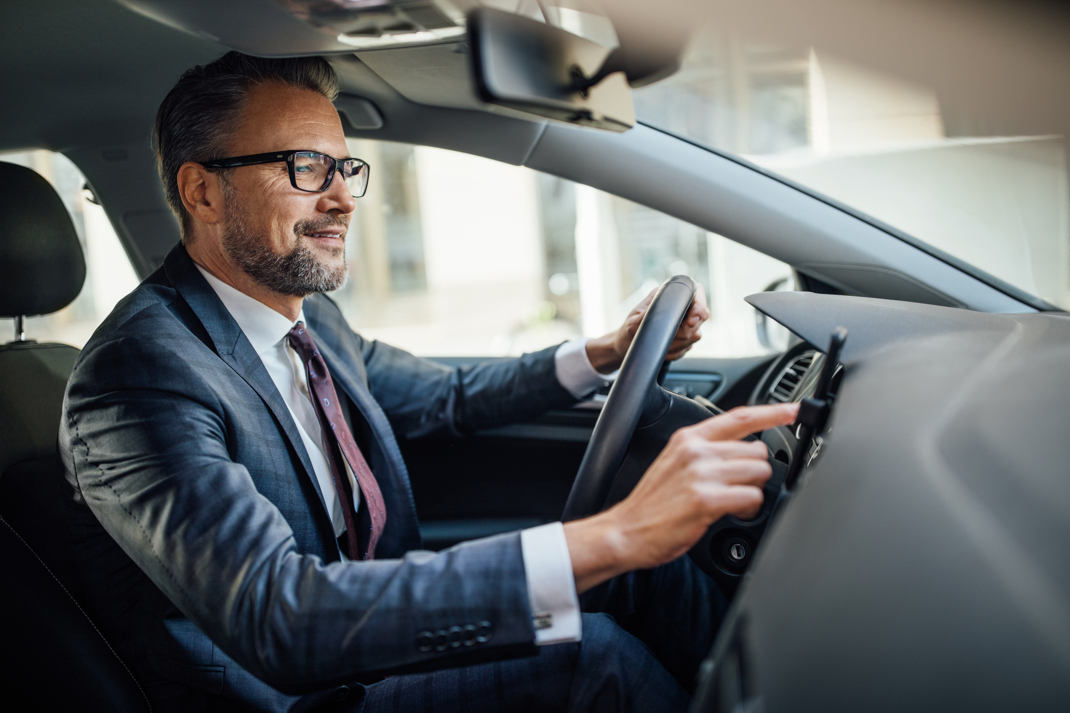 Businessman searching location phone while driving a car