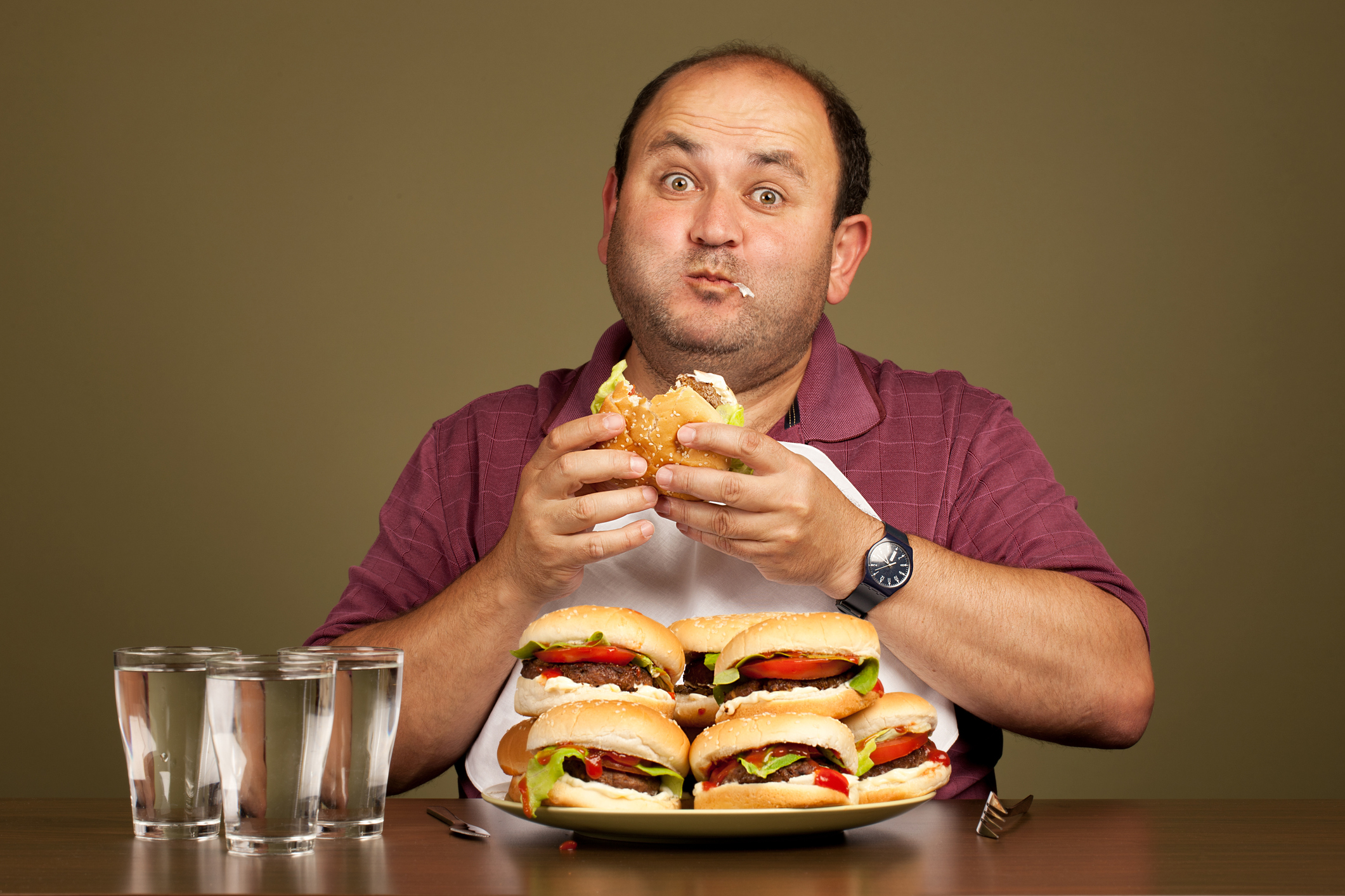 Man eating many burgers