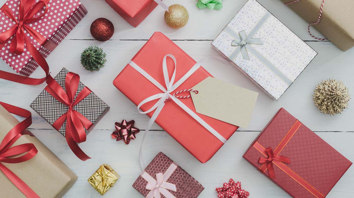 Paper tag with Christmas and New Year holidays gift box with decorative ornament on white wooden table.Gifts and congratulations concept.
