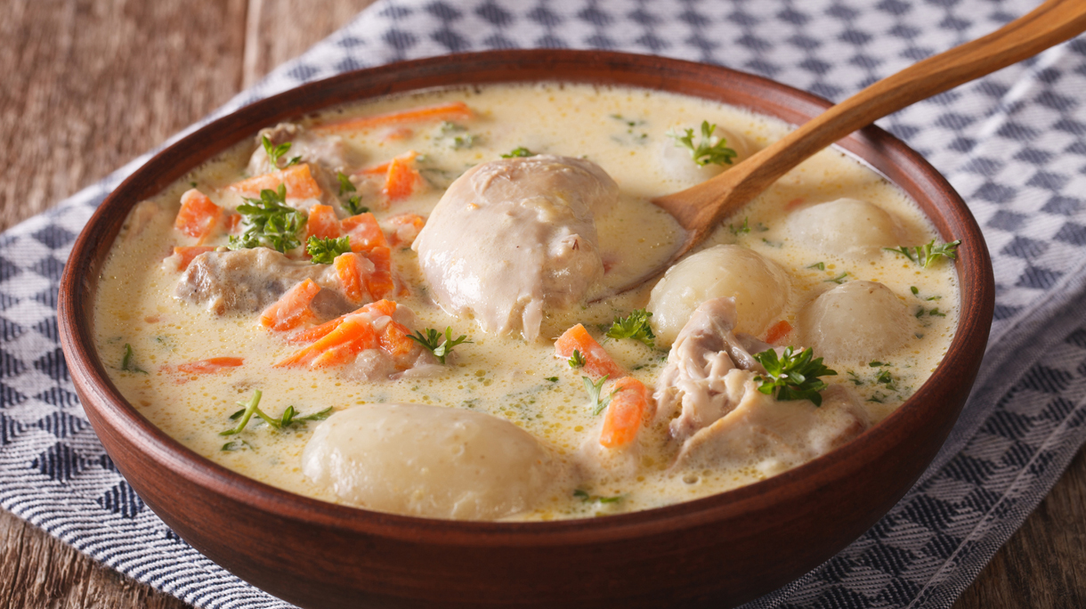 Creamy soup with chicken and vegetables closeup in a bowl