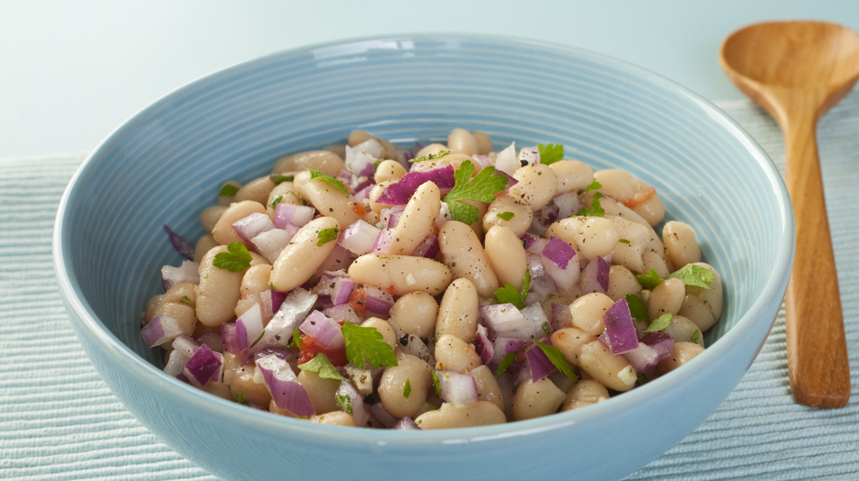 Bowl of fresh bean salad with purple onion