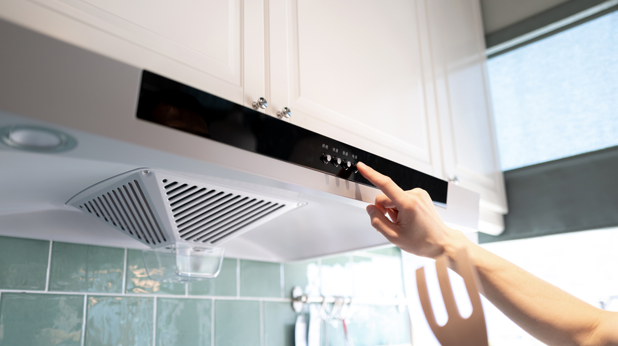 Human hand pushing the button of the kitchen range hood