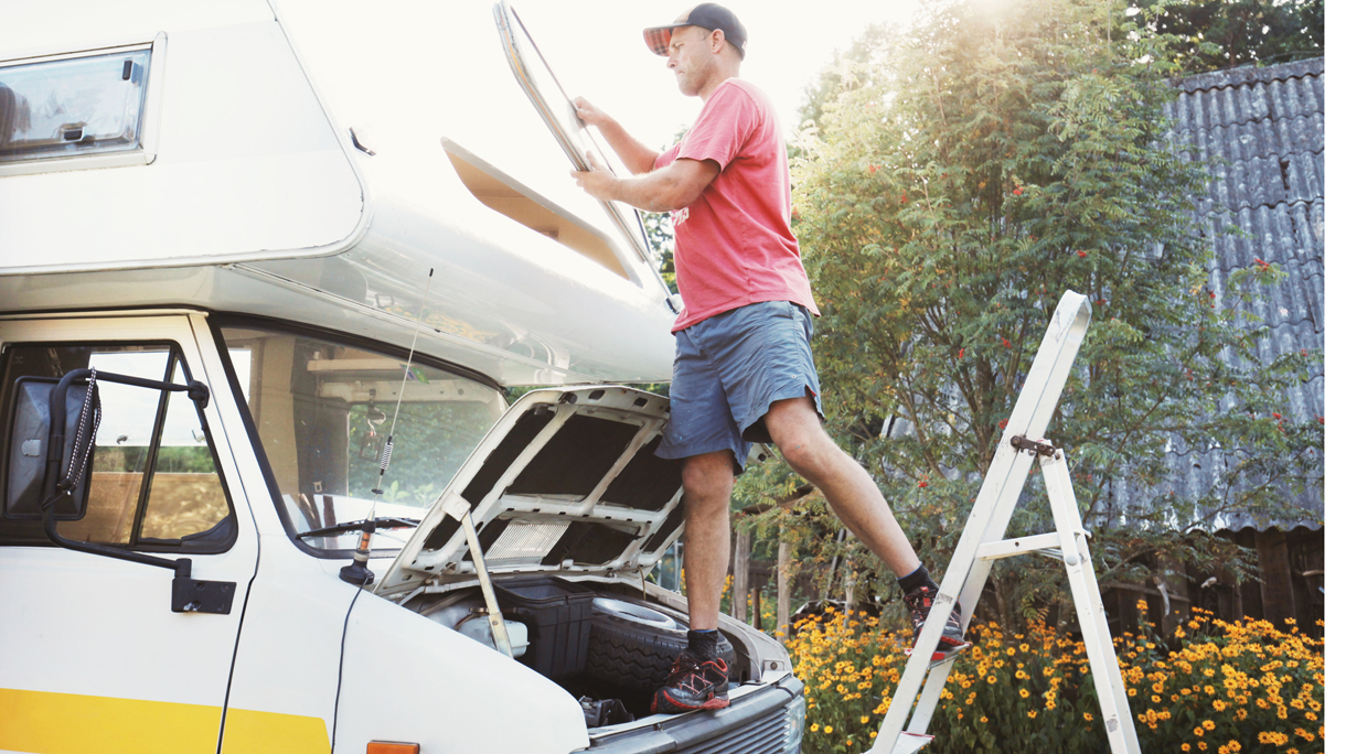 Man fastening window in old campervan