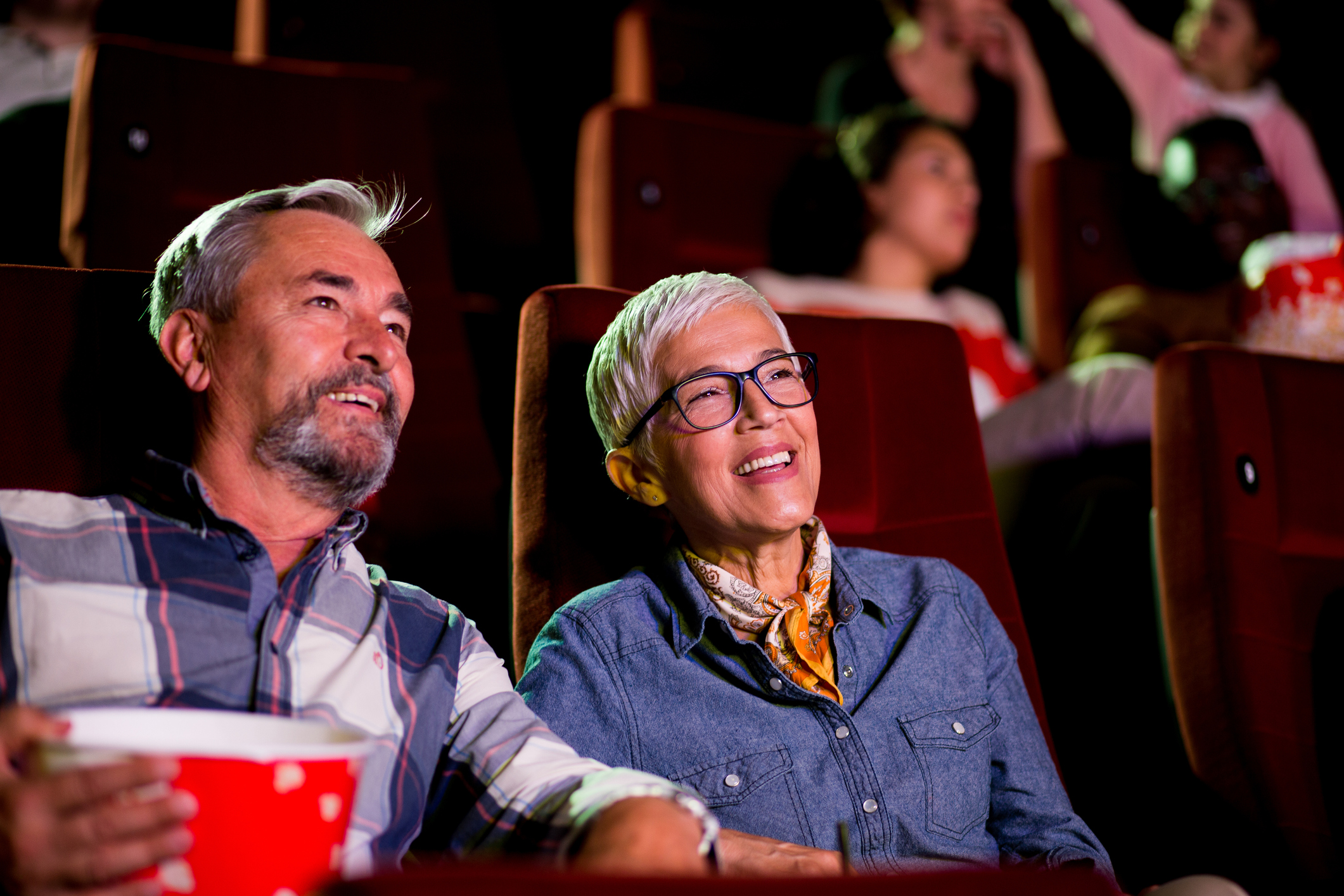 Portrait of a happy senior couple watching a relaxing movie at the cinema