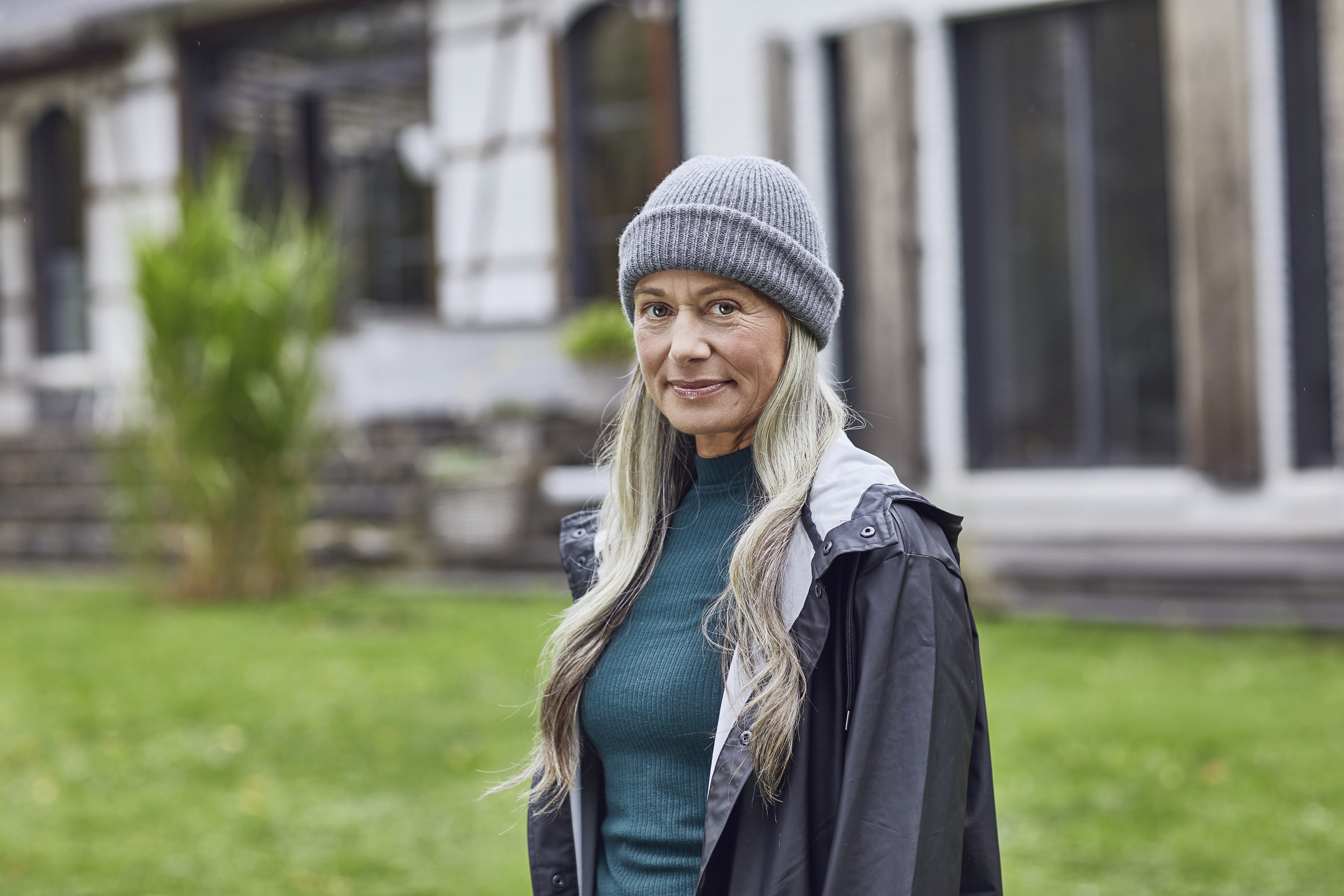 Confident mature woman wearing knit hat in back yard