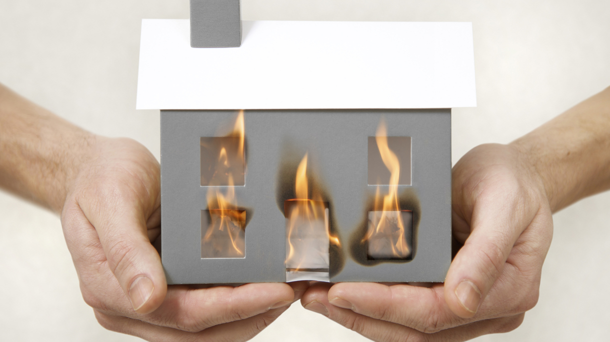Hands holding burning house