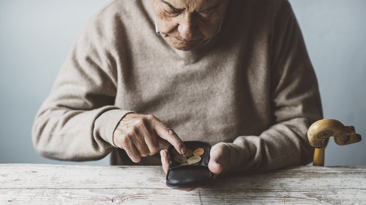 An elderly man look for some money from his wallet