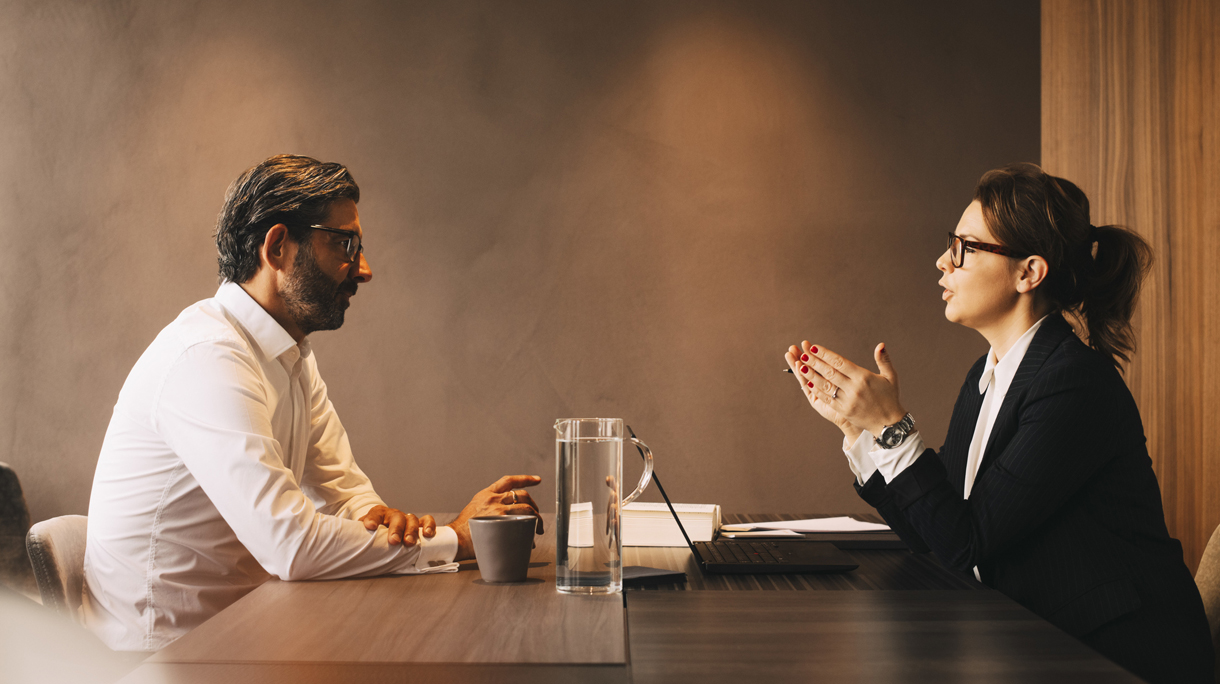 Side view of female lawyer explaining mature client in meeting at office