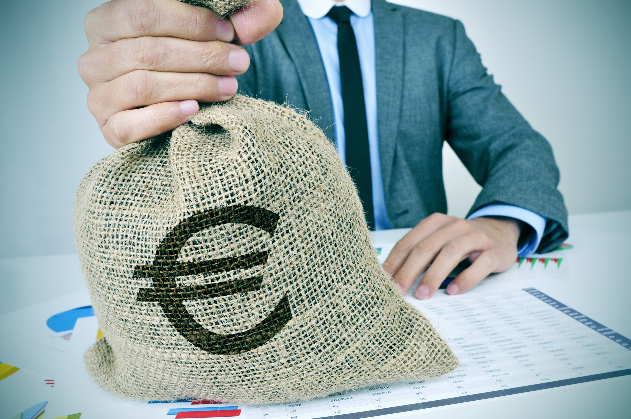 young man in suit with a burlap money bag with the euro sign