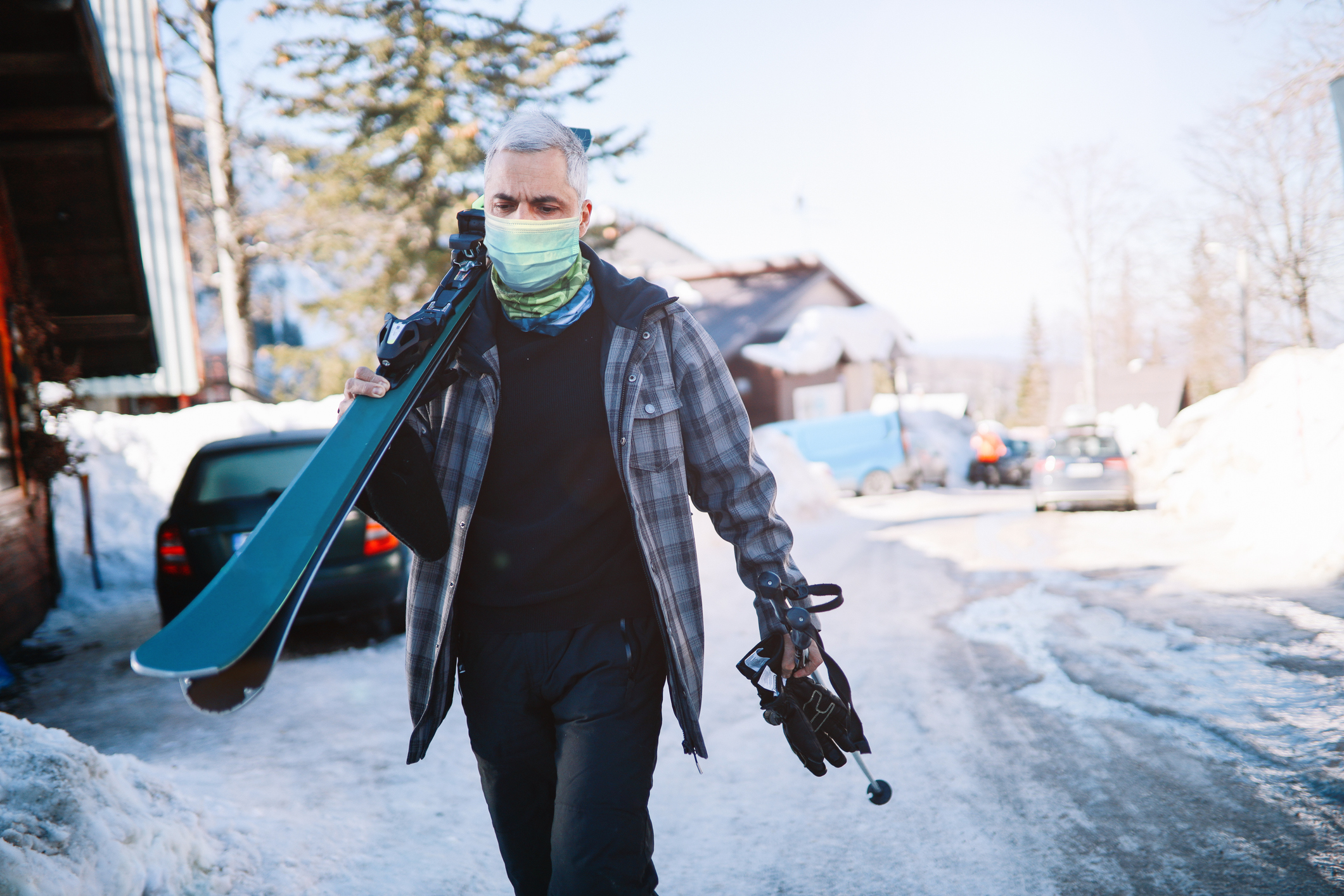 Active older man skiing on the mountain top during pandemic