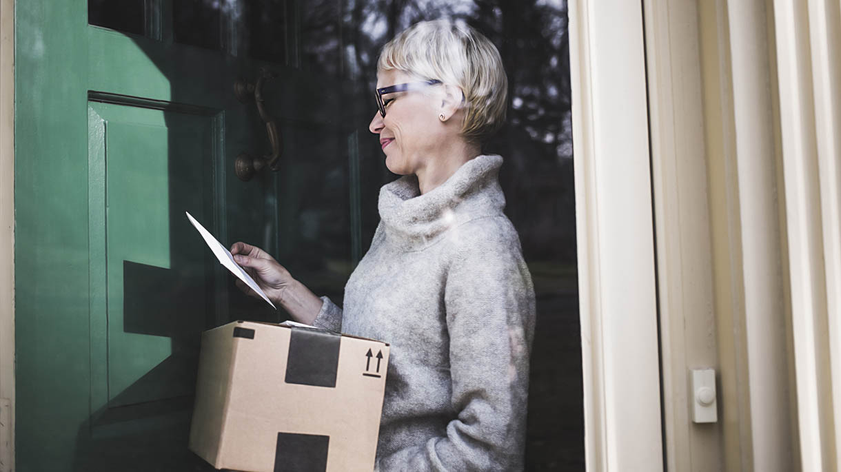 Woman receiving package at front door of home