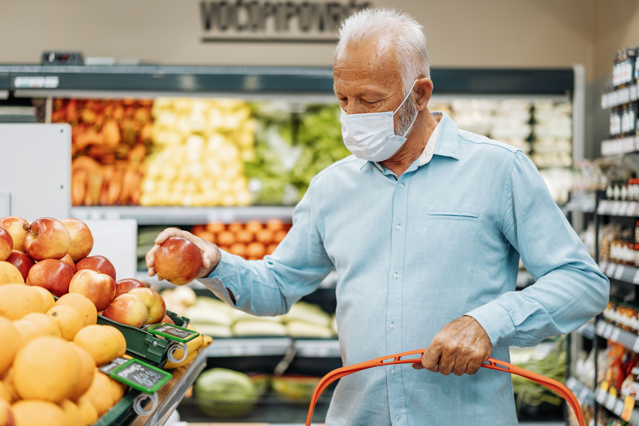 Senior man with face mask buying in supermarket during coronavirus