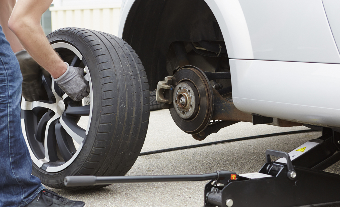 Germany, Bavaria, Kaufbeuren, Mature man changing car tire