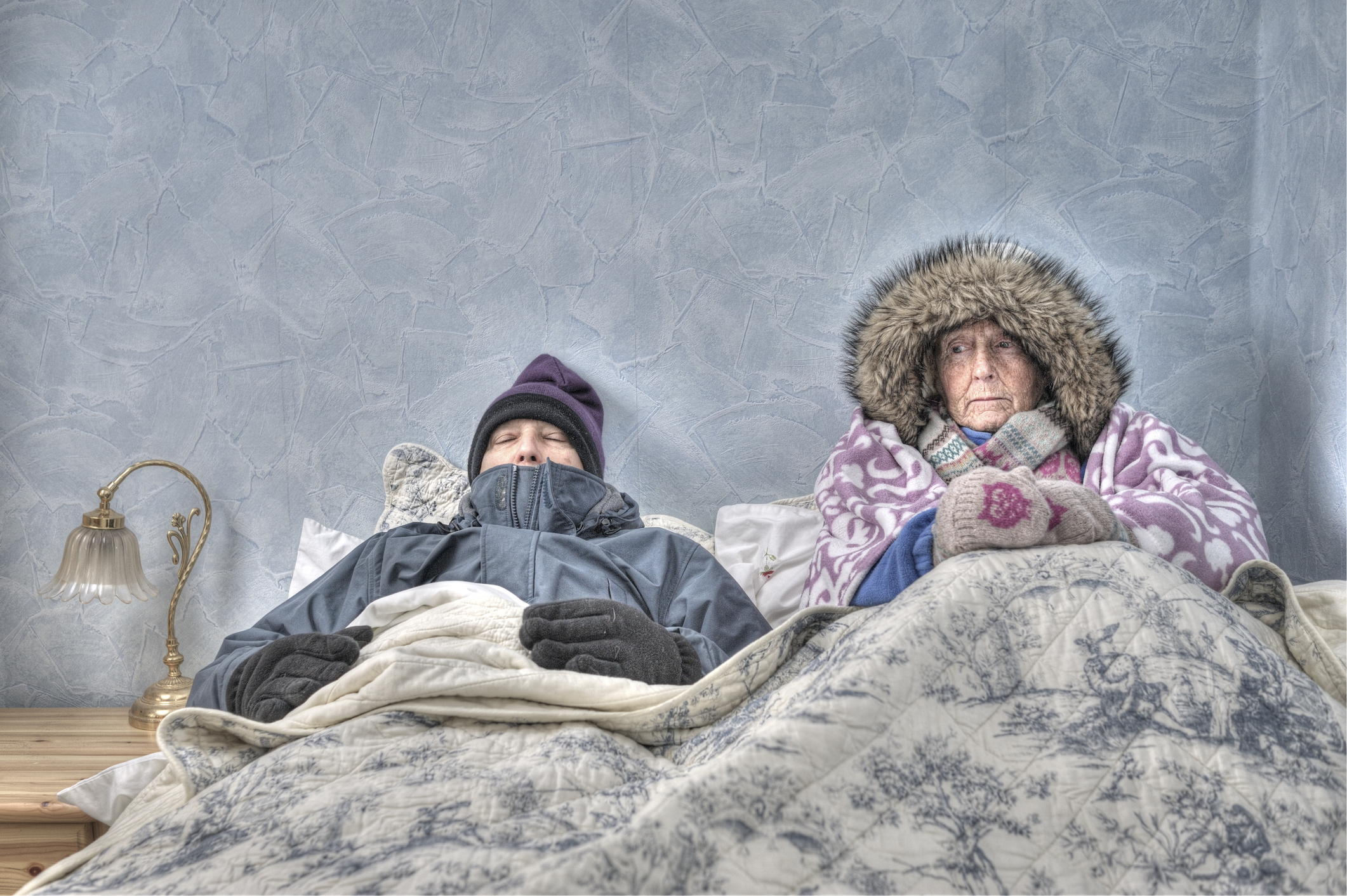 Senior couple, cold and miserable in bed