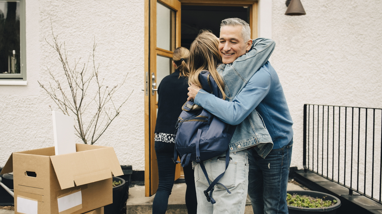 Happy father hugging daughter while standing at back yard