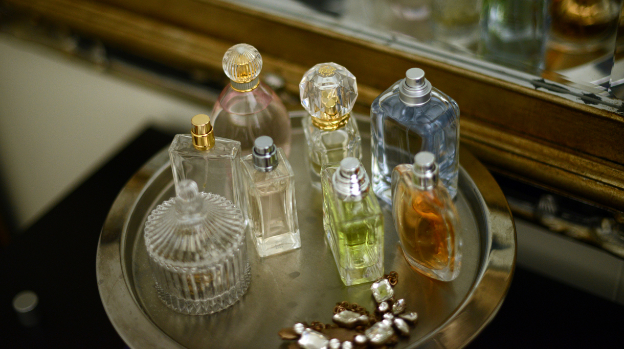 Perfume bottles on a tray by a mirror
