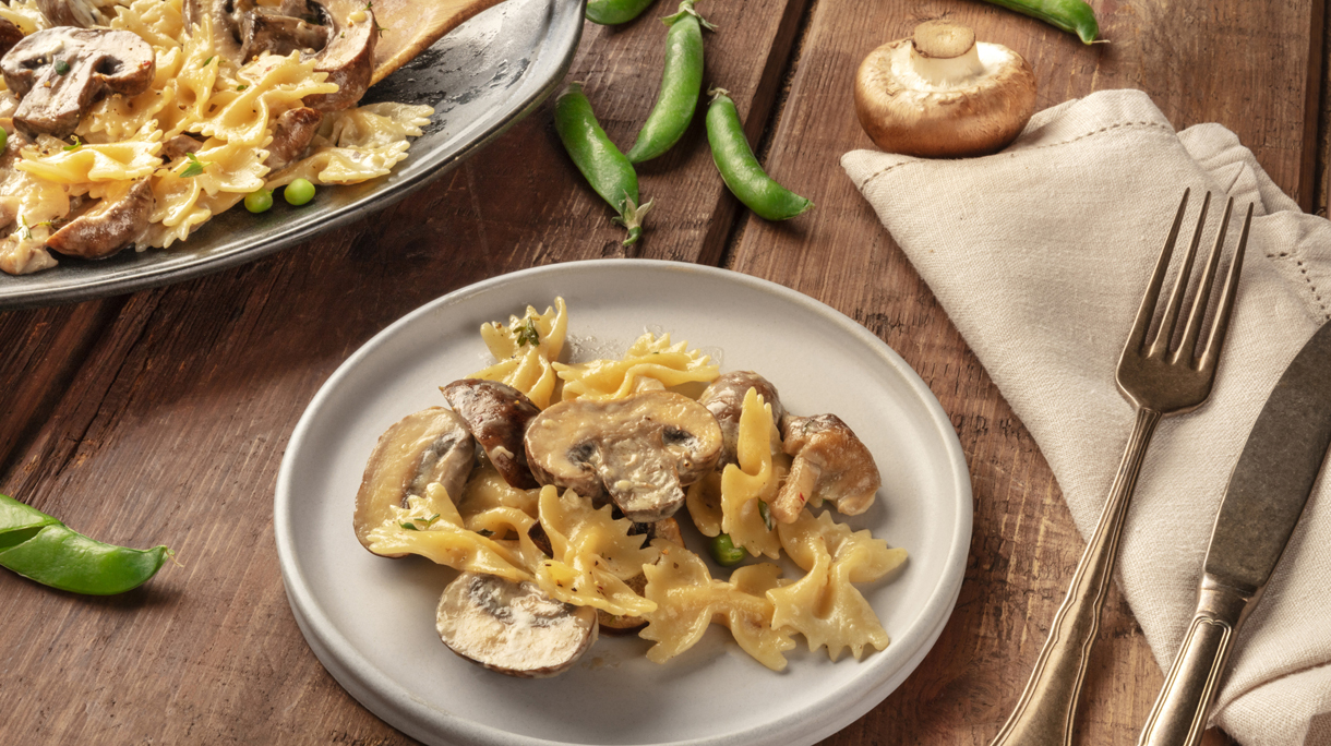 Mushroom and cheese pasta. Farfalle with cremini and green peas