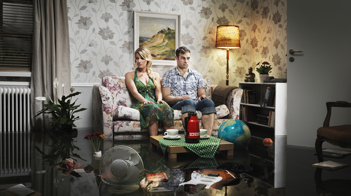 young couple in sofa in a flooded room