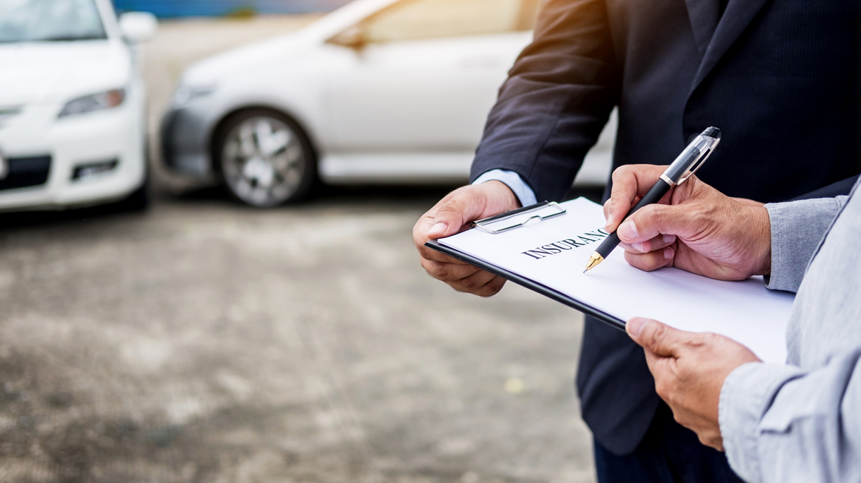 Midsection Of Man Signing Car Insurance Form