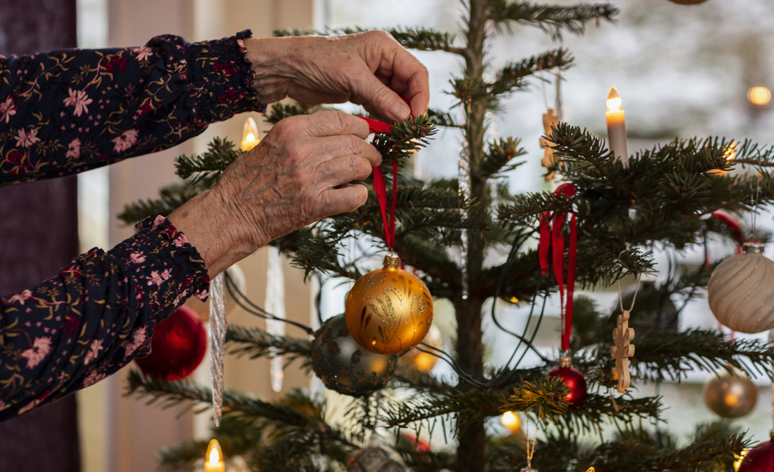 Woman’s hands decorating Christmas tree
