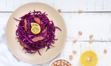 Salad of red cabbage, salami, peanuts on a white wooden background. Top view