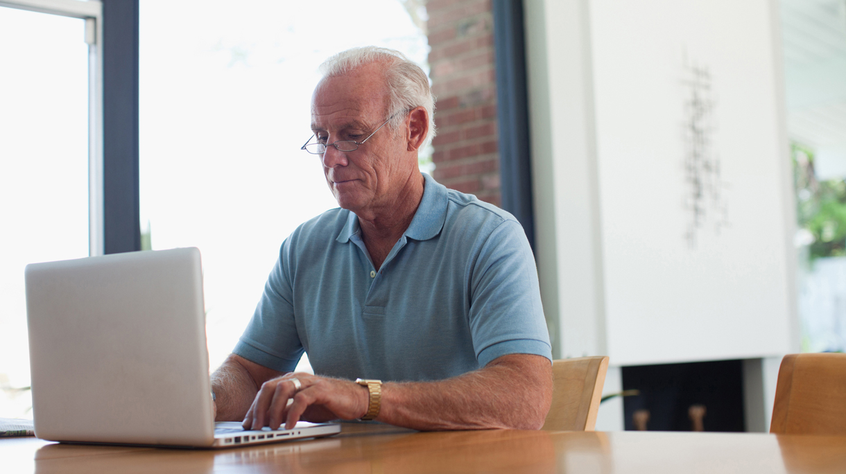 Older man using laptop indoors