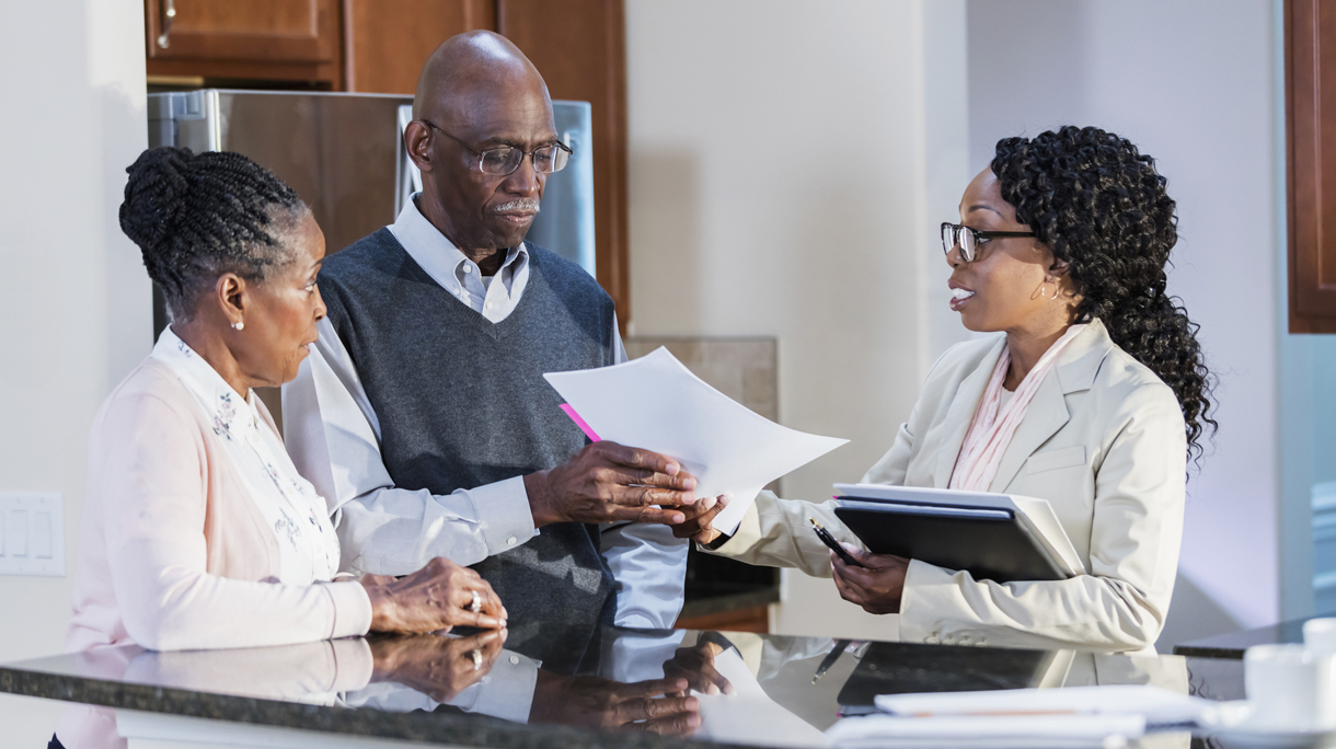 Senior couple at home talking with financial advisor