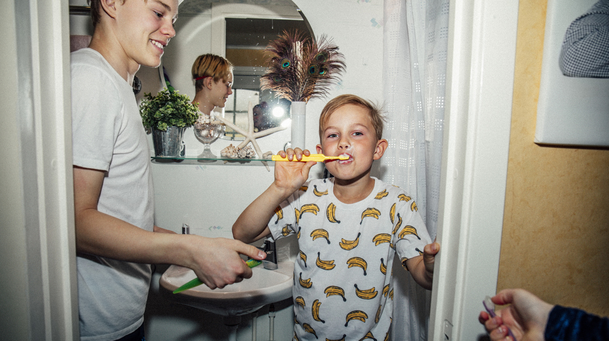 Portrait of boy brushing teeth near bathroom sink