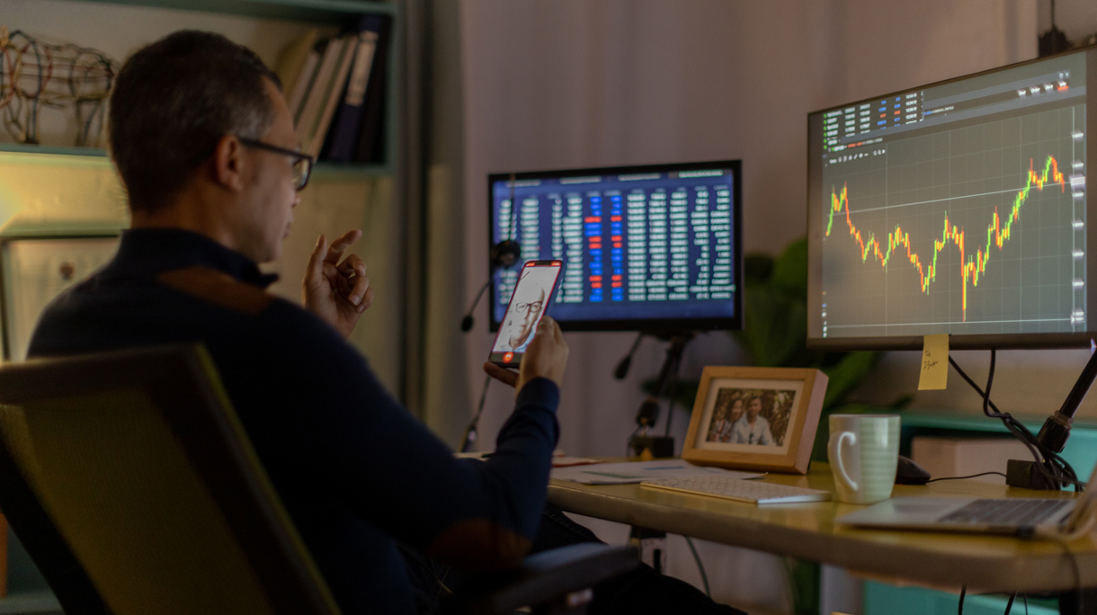Currency trader on video call from his home office