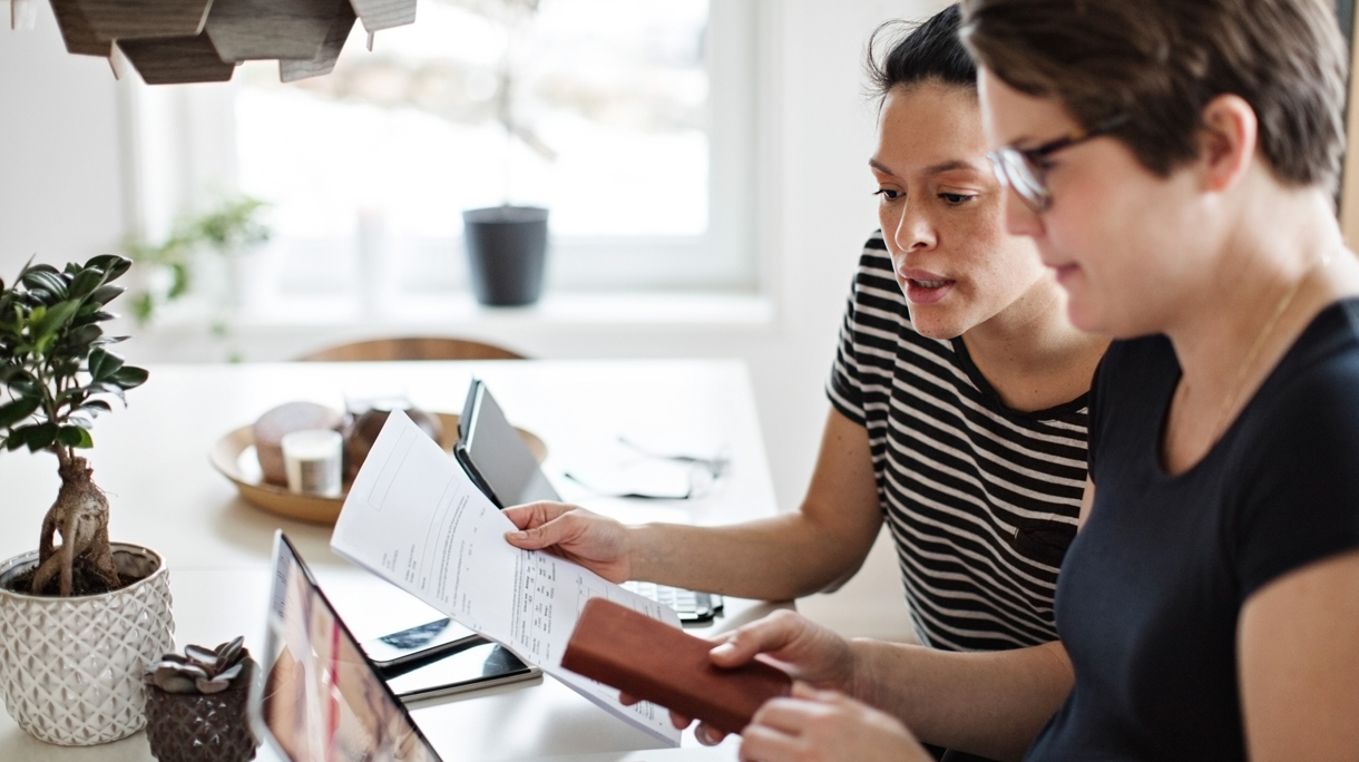 Lesbian couple discussing over financial bills while using laptop at table