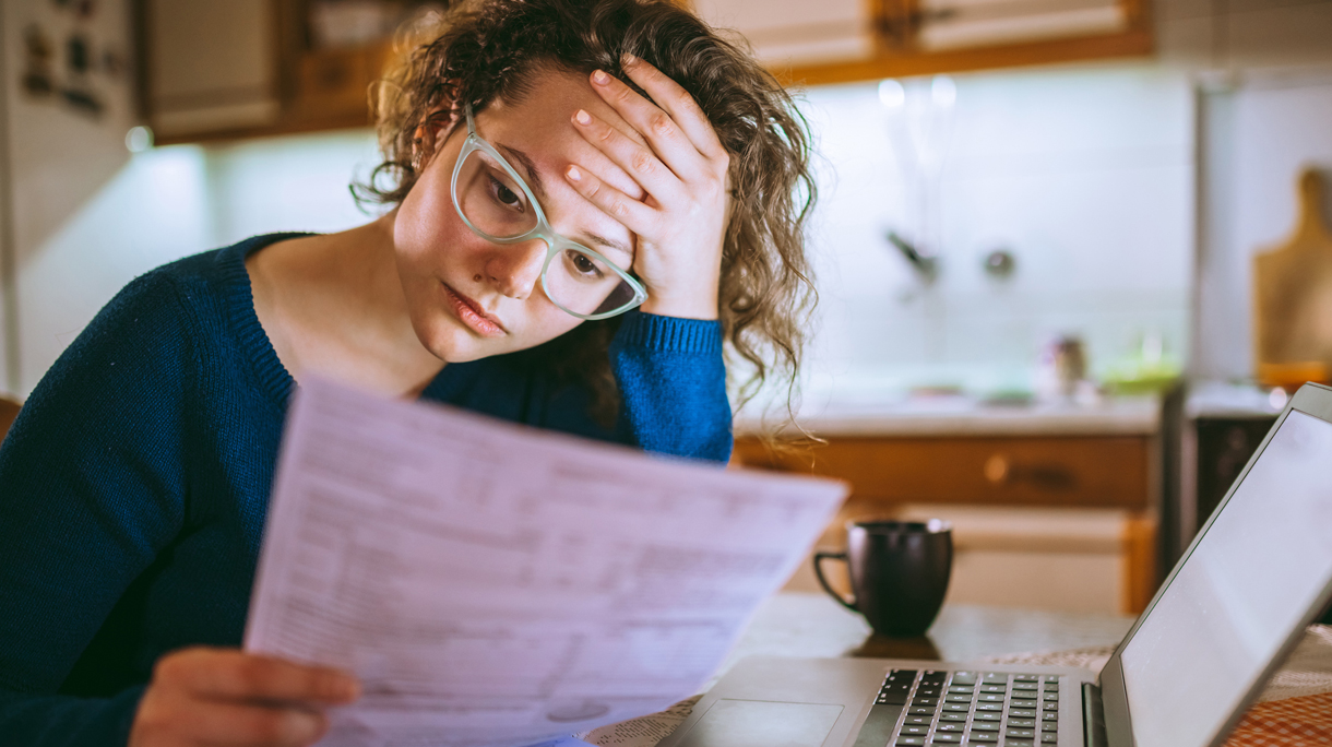 Woman going through bills, looking worried