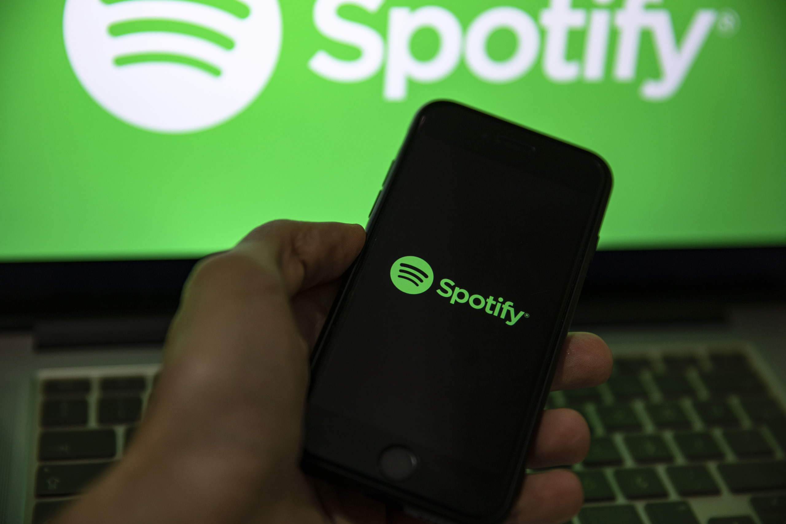 In this photo illustration the Spotify logo seen displayed
