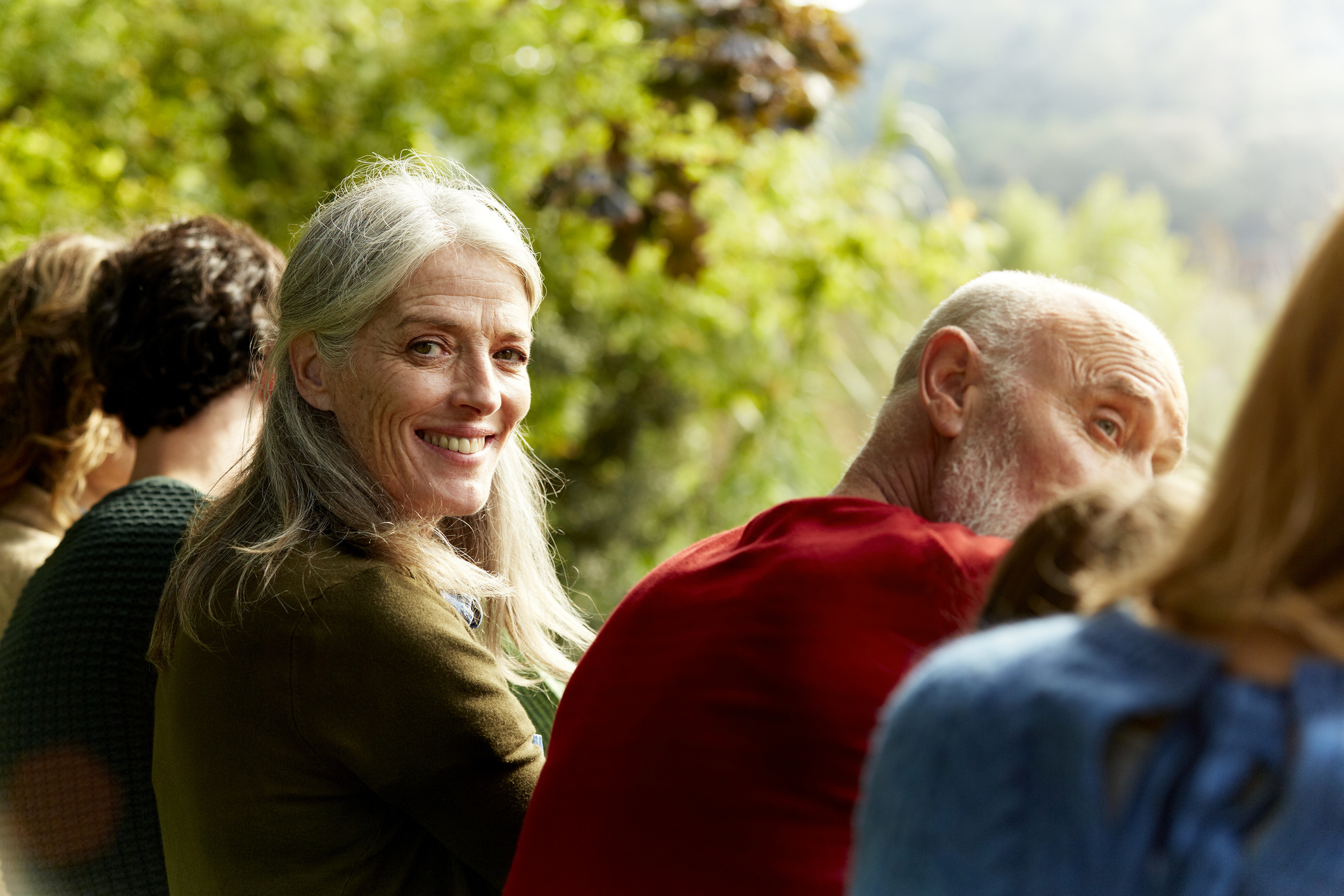 Senior woman sitting with family at park